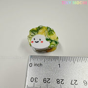 The Kawaii Vegetable Hair Clip Set – 8 Pieces from Tiny Mochi Gift Shop Houston features cute hair clips shaped like veggies. Displayed with a ruler for size, they're perfect for pairing with other kawaii or spooky hair accessories. Brand logo appears top right.